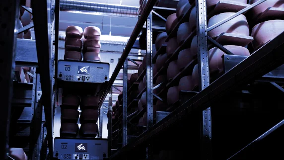 A shuttle system makes its way through a high-density warehouse.